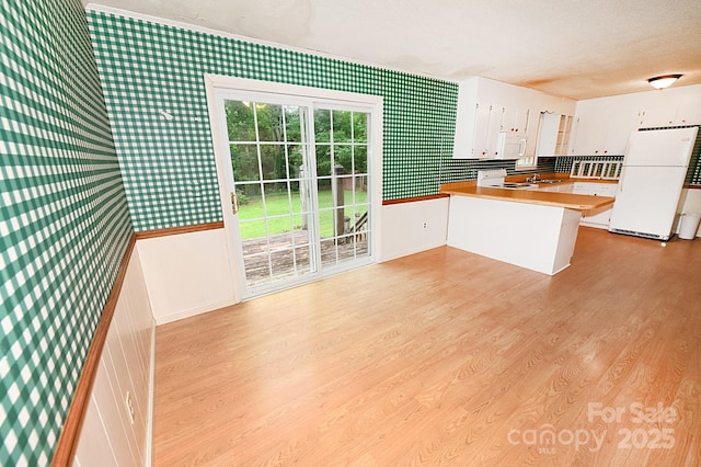2625 Glenn St, Newton, NC 28658 - kitchen with wallpapered walls, white appliances, a peninsula, white cabinetry, and a textured ceiling