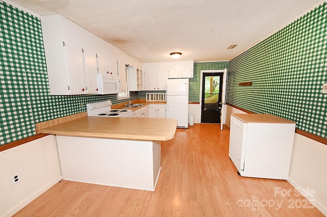2625 Glenn St, Newton, NC 28658 - kitchen with white appliances, light wood-style flooring, a peninsula, a textured ceiling, and a sink