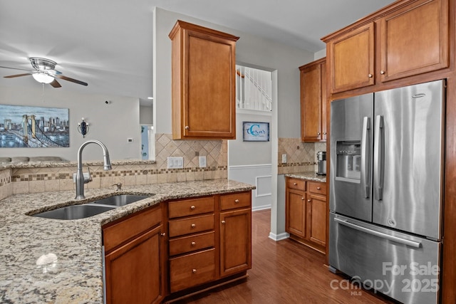 2233 Sonoma Valley Dr, Charlotte, NC 28214 - kitchen featuring stainless steel fridge, decorative backsplash, a ceiling fan, brown cabinetry, and light stone countertops