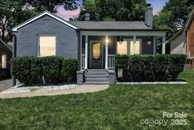 432 4th Street Pl SW, Hickory, NC 28602 - ranch-style house with a yard, covered porch, a chimney, central AC unit, and brick siding