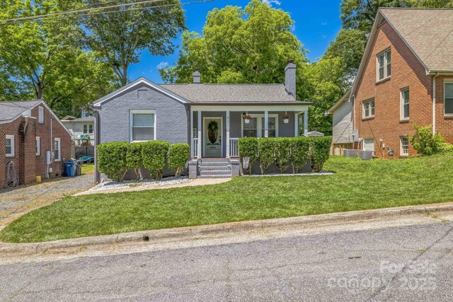432 4th Street Pl SW, Hickory, NC 28602 - view of front of house with a chimney, a front yard, covered porch, central AC, and brick siding