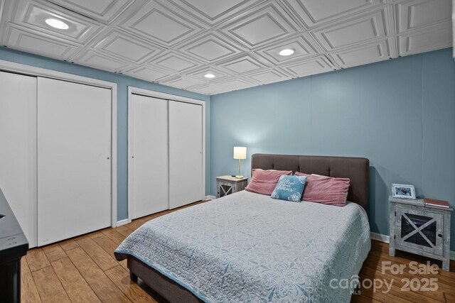 4043 Windward Dr, Tega Cay, SC 29708 - bedroom with two closets, an ornate ceiling, recessed lighting, and wood finished floors