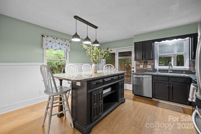 4043 Windward Dr, Tega Cay, SC 29708 - kitchen featuring dishwasher, a sink, dark cabinets, a textured ceiling, and wainscoting
