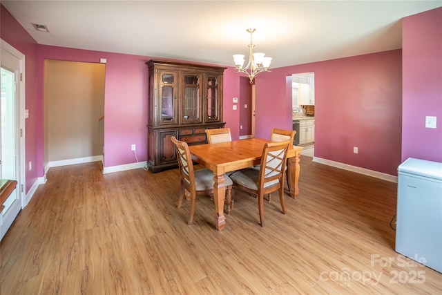 2411 Allendale Cir, Lenoir, NC 28645 - dining room with a chandelier, baseboards, and light wood-style flooring