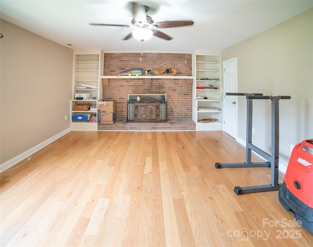 2411 Allendale Cir, Lenoir, NC 28645 - exercise room with built in features, a ceiling fan, a wood stove, and wood finished floors