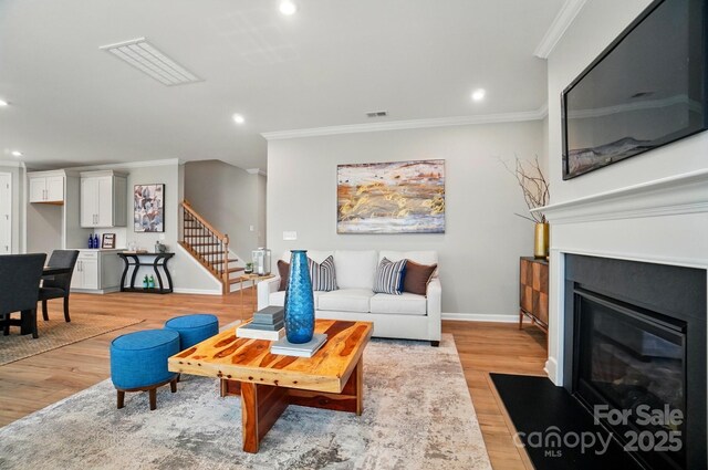 9930 Cask Way, Huntersville, NC 28078 - living room featuring ornamental molding, stairway, light wood finished floors, recessed lighting, and a fireplace with flush hearth