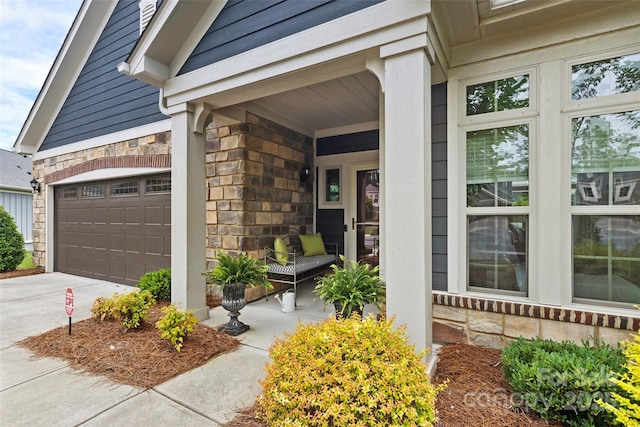 1712 Askern Ct, Waxhaw, NC 28173 - doorway to property featuring stone siding, concrete driveway, an attached garage, and covered porch