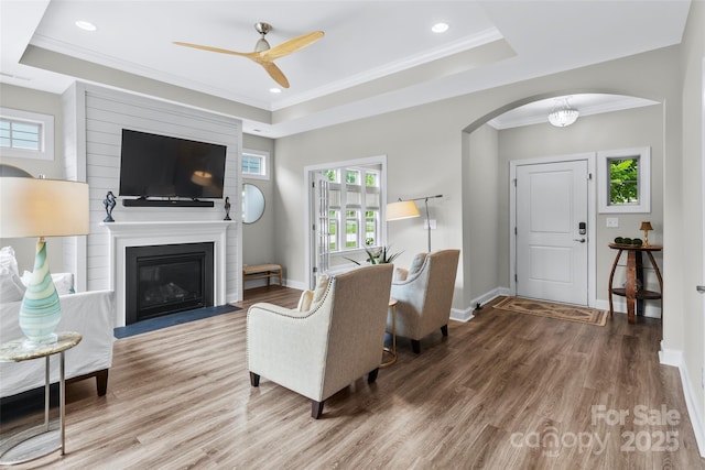 1712 Askern Ct, Waxhaw, NC 28173 - living area featuring wood finished floors, a tray ceiling, arched walkways, ceiling fan, and ornamental molding