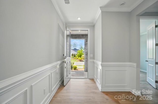9957 Cask Way, Huntersville, NC 28078 - entryway featuring ornamental molding, light wood-style floors, a decorative wall, wainscoting, and recessed lighting