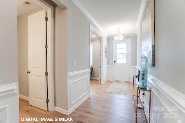 9842 Quercus Ln, Huntersville, NC 28078 - entrance foyer with crown molding, light wood-type flooring, wainscoting, and a decorative wall