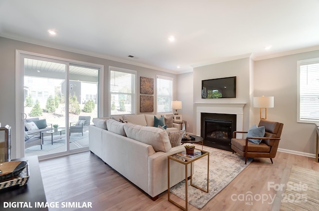 9842 Quercus Ln, Huntersville, NC 28078 - living area featuring crown molding, a glass covered fireplace, light wood finished floors, baseboards, and recessed lighting