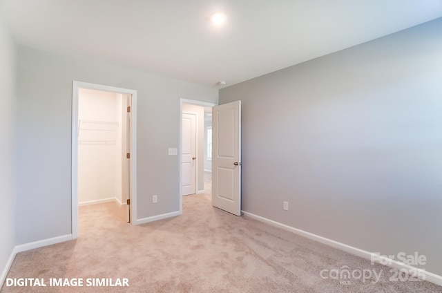 9842 Quercus Ln, Huntersville, NC 28078 - unfurnished bedroom featuring a walk in closet, baseboards, light colored carpet, and a closet