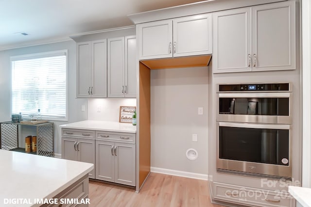 9842 Quercus Ln, Huntersville, NC 28078 - kitchen featuring stainless steel double oven, light wood finished floors, light countertops, baseboards, and ornamental molding