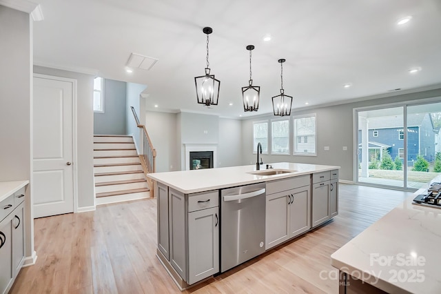 9934 Cask Way, Huntersville, NC 28078 - kitchen with appliances with stainless steel finishes, a sink, gray cabinets, light wood-style floors, and a glass covered fireplace