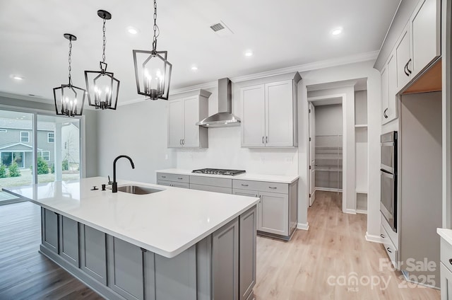 9934 Cask Way, Huntersville, NC 28078 - kitchen featuring wall chimney exhaust hood, a sink, appliances with stainless steel finishes, gray cabinetry, and ornamental molding