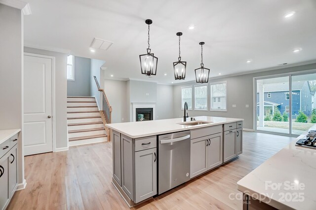9934 Cask Way, Huntersville, NC 28078 - kitchen featuring stainless steel appliances, gray cabinetry, light wood finished floors, a glass covered fireplace, and hanging light fixtures