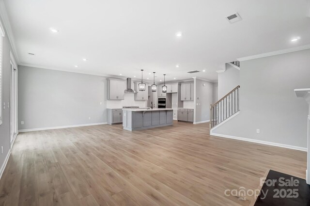 9934 Cask Way, Huntersville, NC 28078 - unfurnished living room with ornamental molding, recessed lighting, stairway, and light wood-type flooring
