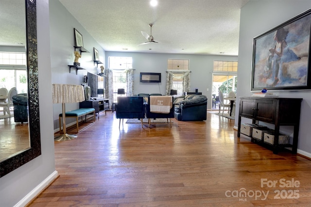 2936 Walsingham Ct, Matthews, NC 28105 - living room featuring ceiling fan, wood finished floors, a fireplace, and a textured ceiling
