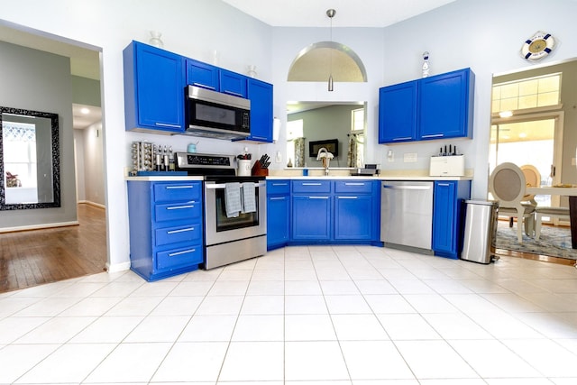 2936 Walsingham Ct, Matthews, NC 28105 - kitchen featuring stainless steel appliances, blue cabinetry, light countertops, and healthy amount of natural light