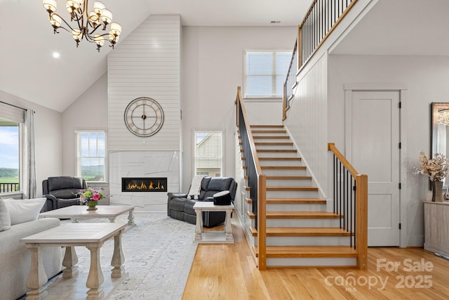 301 Rockbridge Rd Unit 22, Mills River, NC 28759 - living area featuring stairs, high vaulted ceiling, wood finished floors, a tiled fireplace, and a chandelier