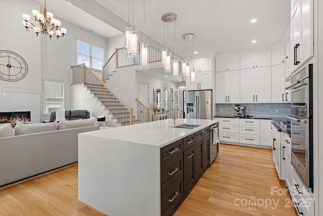 301 Rockbridge Rd Unit 22, Mills River, NC 28759 - kitchen with appliances with stainless steel finishes, a sink, white cabinetry, dark brown cabinetry, and light wood-style floors