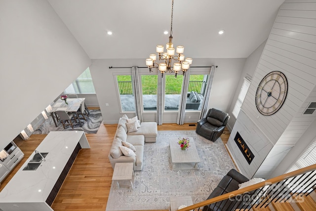 301 Rockbridge Rd Unit 22, Mills River, NC 28759 - living room featuring light wood-style flooring, a chandelier, lofted ceiling, baseboards, and a lit fireplace