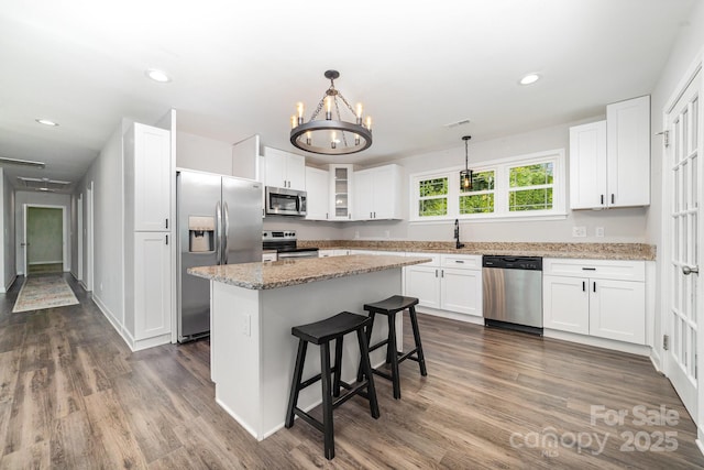 1632 Charles Raper Jonas Hwy, Mount Holly, NC 28120 - kitchen featuring appliances with stainless steel finishes, white cabinetry, glass insert cabinets, dark wood finished floors, and light stone countertops