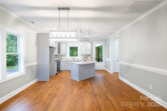 219 Grayson St, Sparta, NC 28675 - kitchen featuring a sink, a kitchen island, wood finished floors, white cabinetry, and baseboards