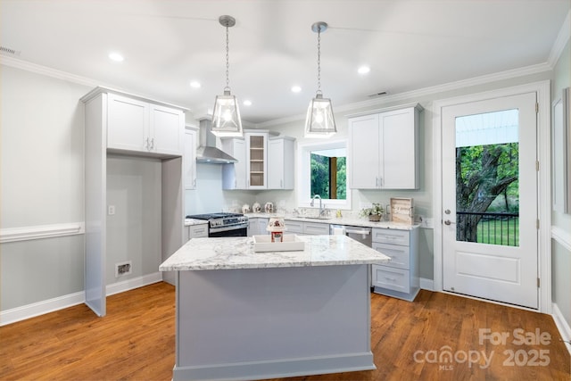 219 Grayson St, Sparta, NC 28675 - kitchen with stainless steel appliances, a sink, a center island, crown molding, and wall chimney exhaust hood