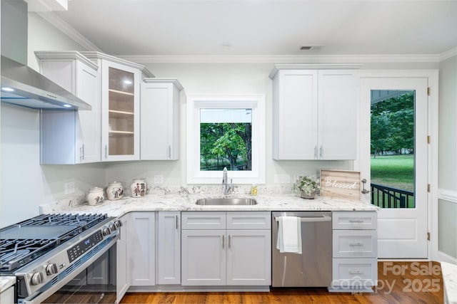219 Grayson St, Sparta, NC 28675 - kitchen with stainless steel appliances, a sink, wall chimney range hood, crown molding, and glass insert cabinets