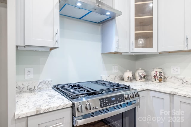 219 Grayson St, Sparta, NC 28675 - kitchen with stainless steel gas stove, ventilation hood, white cabinets, glass insert cabinets, and light stone counters