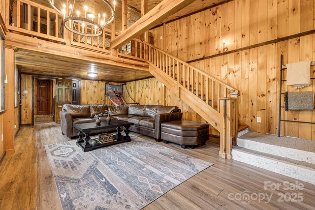 6541 Grassy Branch Rd, Bryson City, NC 28713 - living area featuring wood walls, stairs, wood finished floors, a towering ceiling, and a chandelier