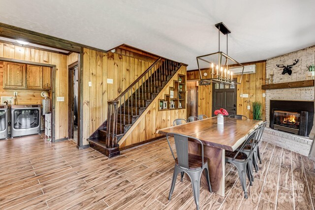 6541 Grassy Branch Rd, Bryson City, NC 28713 - dining area featuring wooden walls, washer and dryer, stairs, light wood finished floors, and a brick fireplace