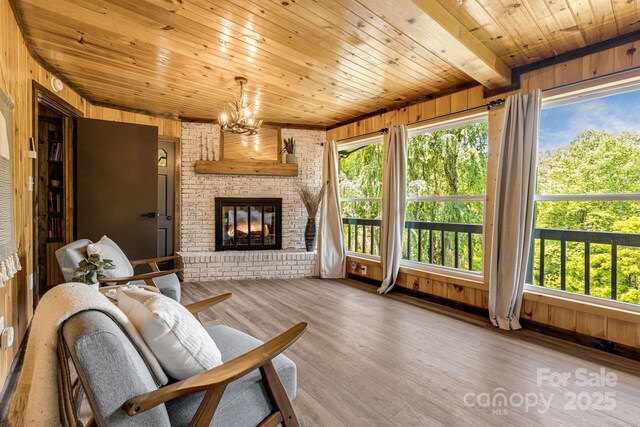 6541 Grassy Branch Rd, Bryson City, NC 28713 - living area featuring wood ceiling, wood walls, a chandelier, wood finished floors, and a fireplace