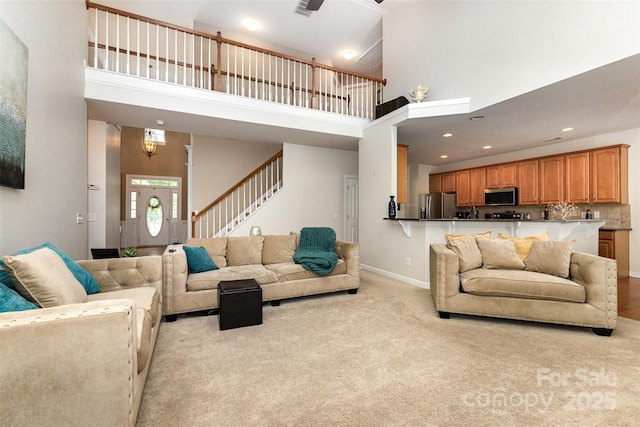 9814 Tompkins Ln, Waxhaw, NC 28173 - living room featuring a high ceiling, light colored carpet, stairway, recessed lighting, and baseboards