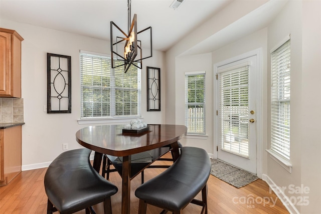 9814 Tompkins Ln, Waxhaw, NC 28173 - dining space featuring light wood-style floors, a chandelier, healthy amount of natural light, and baseboards