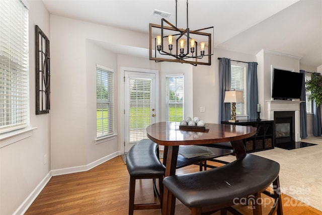 9814 Tompkins Ln, Waxhaw, NC 28173 - dining room with a chandelier, baseboards, a fireplace with flush hearth, and light wood-type flooring