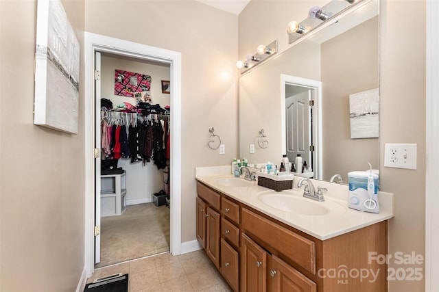 9814 Tompkins Ln, Waxhaw, NC 28173 - bathroom with double vanity, a walk in closet, tile patterned flooring, and baseboards