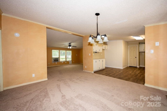 155 Springdale Acres Dr, Mooresville, NC 28115 - unfurnished living room featuring dark carpet, crown molding, a textured ceiling, ceiling fan, and a chandelier