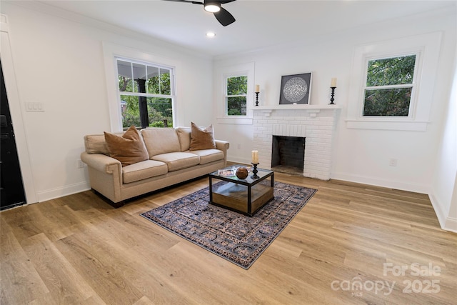 940 N New Hope Rd, Gastonia, NC 28054 - living area featuring ceiling fan, crown molding, light wood finished floors, baseboards, and a brick fireplace