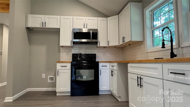 148 Forest Heights Dr, Mcadenville, NC 28101 - kitchen featuring stainless steel microwave, black range with electric cooktop, dark wood-style flooring, lofted ceiling, and white cabinetry