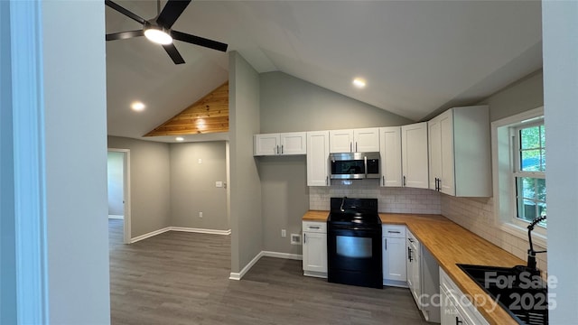 148 Forest Heights Dr, Mcadenville, NC 28101 - kitchen with black range with electric cooktop, stainless steel microwave, wood counters, white cabinetry, and decorative backsplash