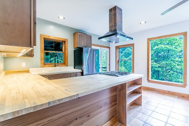 1146 Thomas Branch Rd, Marshall, NC 28753 - kitchen with wall chimney exhaust hood, stainless steel appliances, baseboards, open shelves, and light tile patterned floors