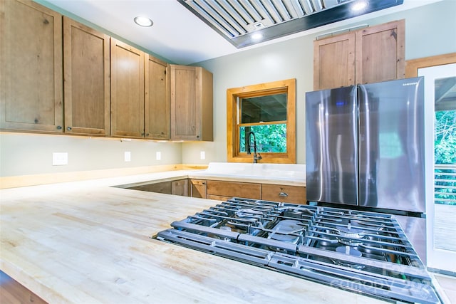 1146 Thomas Branch Rd, Marshall, NC 28753 - kitchen featuring freestanding refrigerator, light countertops, wall chimney range hood, a sink, and cooktop