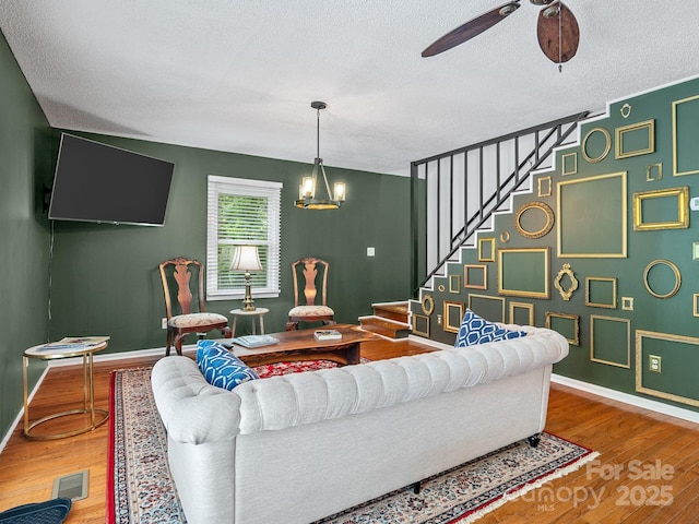 192 Shady Ln, Mill Spring, NC 28756 - living room featuring stairs, a textured ceiling, wood finished floors, ceiling fan, and a chandelier