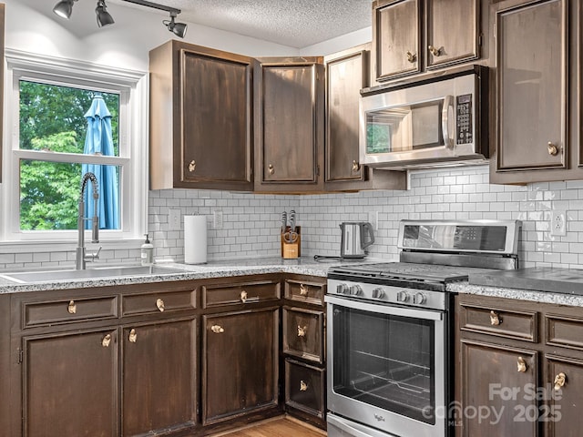 192 Shady Ln, Mill Spring, NC 28756 - kitchen featuring appliances with stainless steel finishes, dark brown cabinets, decorative backsplash, plenty of natural light, and a textured ceiling