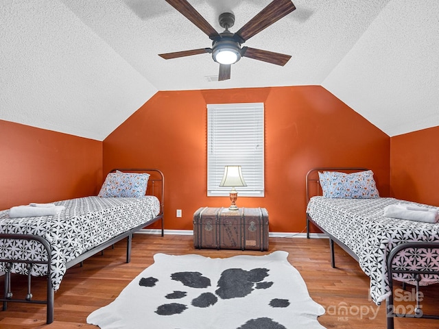 192 Shady Ln, Mill Spring, NC 28756 - bedroom featuring a textured ceiling, wood finished floors, lofted ceiling, and ceiling fan