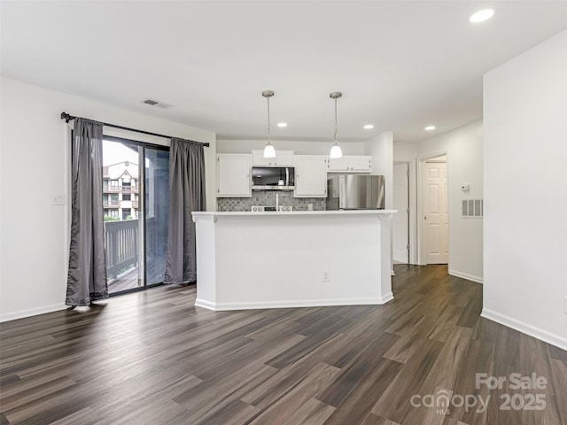 8183 Cedar Glen Dr, Charlotte, NC 28212 - kitchen with stainless steel appliances, dark wood-style floors, white cabinetry, backsplash, and hanging light fixtures