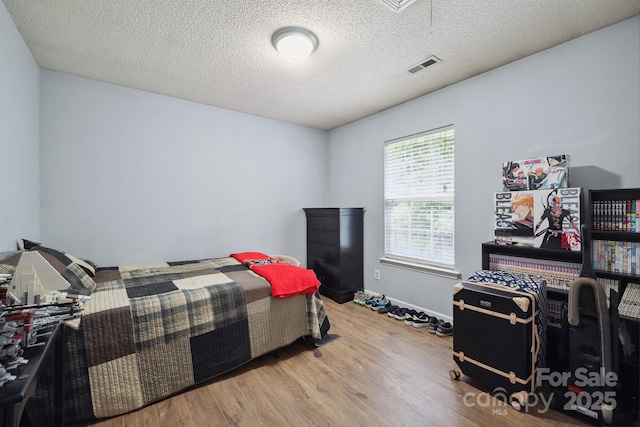1912 8th St SE, Hickory, NC 28602 - bedroom with wood finished floors, baseboards, and a textured ceiling