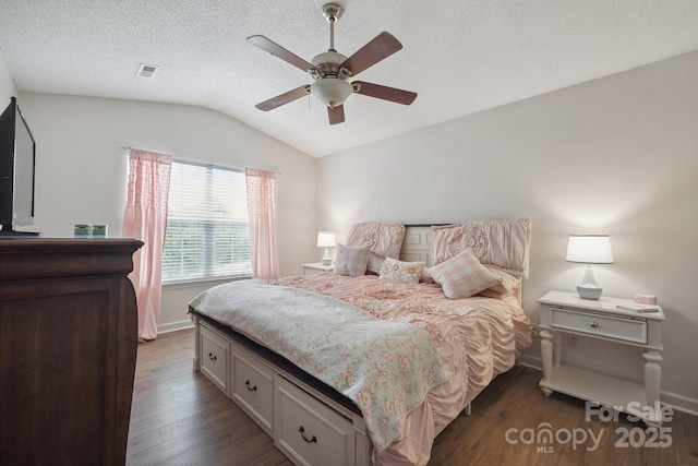 1912 8th St SE, Hickory, NC 28602 - bedroom with lofted ceiling, dark wood-style flooring, baseboards, ceiling fan, and a textured ceiling